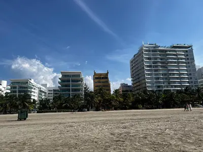 a beach with buildings and palm trees in the background at Morros 922 Beach House in Cartagena de Indias