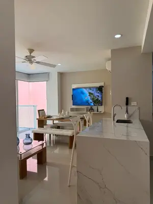 a kitchen and dining room with a table and a tv at Morros 922 Beach House in Cartagena de Indias