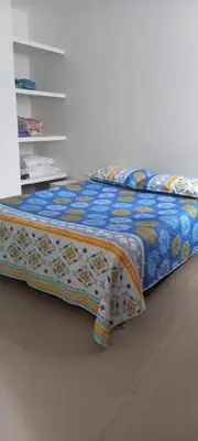 a bed with a blue comforter on top of it at Apartamento El Cabrero in Cartagena de Indias