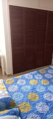 a bedroom with a bed with a blue and yellow quilt at Apartamento El Cabrero in Cartagena de Indias