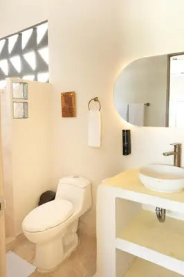 a white bathroom with a toilet and a sink at Villa con piscina privada en coveñas sucre in Coveñas