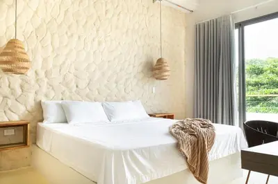 a bedroom with a white bed with a stone wall at Villa privada en coveñas sucre in Coveñas