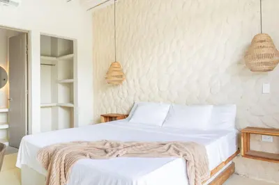 a bedroom with a bed and two pendant lights at Villa privada en coveñas sucre in Coveñas