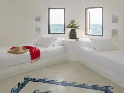 a white bedroom with a bed and two windows at Isla Pelícano in Isla Grande