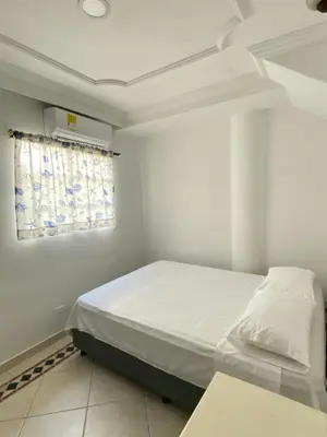 a white bedroom with a bed and a window at Muy cerca del mar, areopuerto y centro histórico in Cartagena de Indias