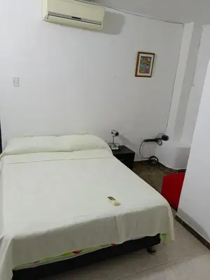 a bedroom with a white bed with a white blanket at Casa Topacio in Cartagena de Indias