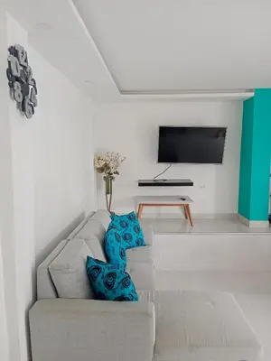a living room with a couch and a tv at Casa Topacio in Cartagena de Indias