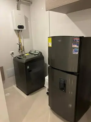 a black refrigerator and a trash can in a room at Amplio y hermoso apartamento para disfrutar in Barranquilla