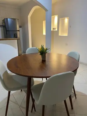 a wooden table with chairs and a potted plant on it at Cómodo apartamento para hospedaje in Cartagena de Indias