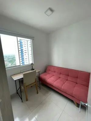 a red couch sitting in a room with a table at Ambiente Caribe! piso 26 - 3 hab in Cartagena de Indias
