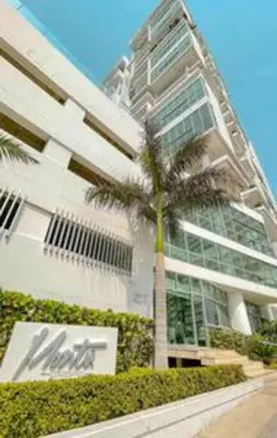 a palm tree in front of a tall building at Luxury View, 3 Rooms in Cartagena de Indias
