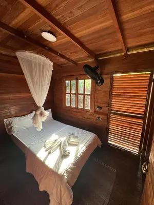 a bedroom with a bed in a wooden room at Cabaña Privada con Piscina y Aire Acondicionado in Isla Fuerte