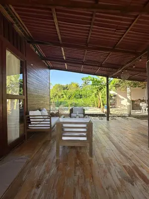 a patio with a table and a couch on a wooden floor at Cabaña Privada con Piscina y Aire Acondicionado in Isla Fuerte