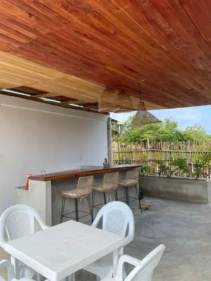 a patio with a table and chairs under a wooden ceiling at Cabaña Privada con Piscina y Aire Acondicionado in Isla Fuerte