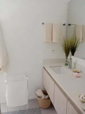 a white bathroom with a sink and a chair at Apartamento en Pozos Colorados Santa Marta Suite 1309 -Pozos Colorados in Santa Marta