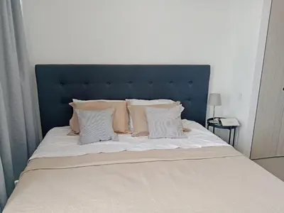 a bed with a blue headboard and white pillows at Apartamento en Pozos Colorados Santa Marta Suite 1309 -Pozos Colorados in Santa Marta