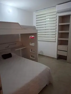 a bedroom with a bed and a desk and a window at Apartamento Cartagena cerca a la playa in Cartagena de Indias