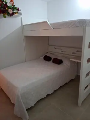 a bunk bed in a small room with a white bed at Apartamento Cartagena cerca a la playa in Cartagena de Indias