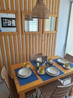a wooden table with plates and cups on it at Apartamento Cartagena cerca a la playa in Cartagena de Indias