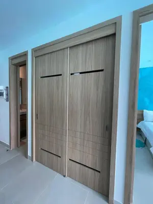 a room with two wooden doors in a bedroom at Apartamento 4g Baia Kristal Cartagena in Cartagena de Indias