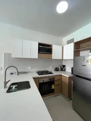 a kitchen with white cabinets and a stainless steel refrigerator at Apartamento 4g Baia Kristal Cartagena in Cartagena de Indias