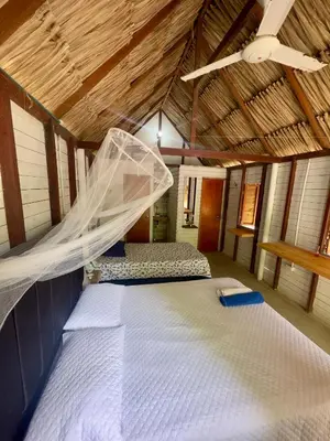 a bedroom with two beds and a mosquito net at Palma Plata islas del Rosario in Isla Grande
