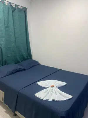 a blue bed with a white dress on it at Hotel Corales del Mar in Cartagena de Indias