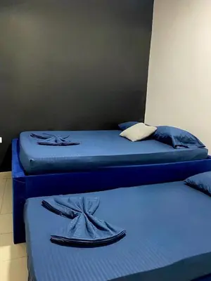 two beds in a room with blue sheets at Hotel Corales del Mar in Cartagena de Indias