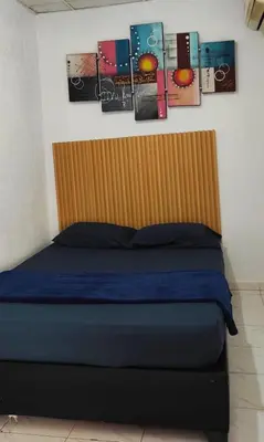 a bed in a room with pictures on the wall at Hotel Corales del Mar in Cartagena de Indias
