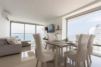 a dining room with a table and chairs and a couch at Awesome Sea View and Historic Center “Morros City” in Cartagena de Indias