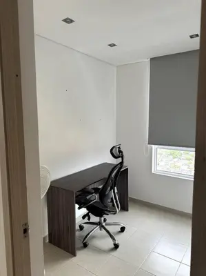 a desk with a chair in a room with a window at Luminoso y confortable in Cartagena de Indias