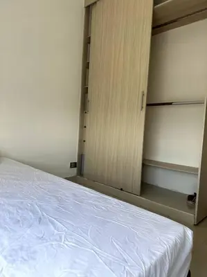 a bedroom with a white bed and a cupboard at Luminoso y confortable in Cartagena de Indias