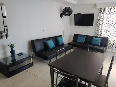 a living room with a black couch and a table at Balcón del mar in Cartagena de Indias