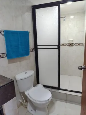 a bathroom with a toilet and a shower with a blue towel at Balcón del mar in Cartagena de Indias