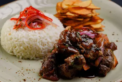 a plate of food with rice and meat and chips at Wyndham Garden Barranquilla in Barranquilla