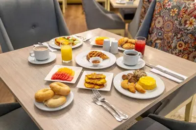a table with plates of breakfast food on it at Wyndham Garden Barranquilla in Barranquilla