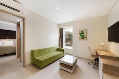 a living room with a green couch and a bed at Wyndham Garden Barranquilla in Barranquilla