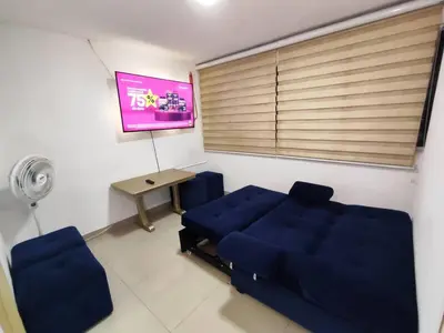 a living room with a blue couch and a table at EM2-1G APARTAMENTO DE 2 HAB CERCA AL MAR ZONA RESIDENCIA WIFi Y PARQUEADERO in Cartagena de Indias