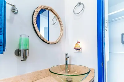 a bathroom with a glass sink and a mirror at Cartagena Paradise Beach Home Sleeps 7 in Cartagena de Indias