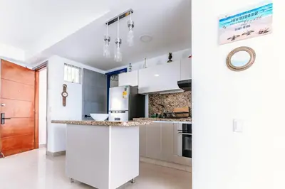a kitchen with white cabinets and a counter top at Cartagena Paradise Beach Home Sleeps 7 in Cartagena de Indias
