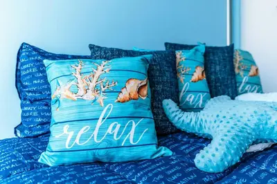 a bed with blue pillows and an octopus pillow at Cartagena Paradise Beach Home Sleeps 7 in Cartagena de Indias