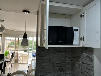 a kitchen with a microwave above a kitchen counter at Apartamento con vista al mar Cartagena piscina in Cartagena de Indias