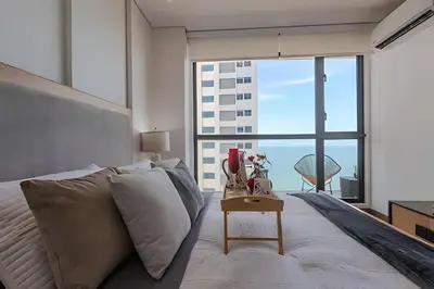 a bedroom with a bed and a large window at Stunning Sea View and Historic Center 20th FL/ 2BR in Cartagena de Indias