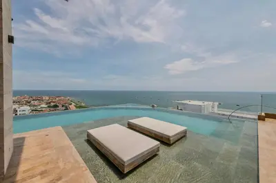 a swimming pool with two beds on top of a building at Stunning Sea View and Historic Center 20th FL/ 2BR in Cartagena de Indias