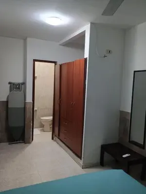 a bathroom with a toilet and a wooden door at Apartamento Cartagena Torices 50 in Cartagena de Indias