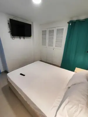 a bedroom with a large white bed and a flat screen tv at EM3-2G APARTAMENTO DE 4 HAB EN ZONA RESIDENCIAL CON AIRE ACONDICIONADO Wifi Y PARQUEADERO in Cartagena de Indias