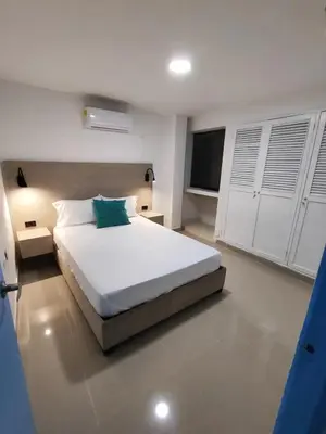 a bedroom with a large white bed and a television at EM3-2G APARTAMENTO DE 4 HAB EN ZONA RESIDENCIAL CON AIRE ACONDICIONADO Wifi Y PARQUEADERO in Cartagena de Indias
