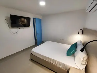 a bedroom with a bed with a tv on the wall at EM3-2G APARTAMENTO DE 4 HAB EN ZONA RESIDENCIAL CON AIRE ACONDICIONADO Wifi Y PARQUEADERO in Cartagena de Indias