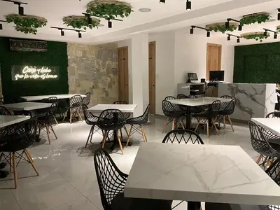 a dining room with tables and chairs and a chalkboard at Hotel fenix in Barranquilla
