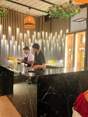 two men standing at a counter in a bar at Hotel fenix in Barranquilla